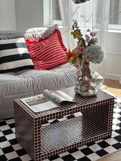 a living room with a white couch and black and white checkered floor