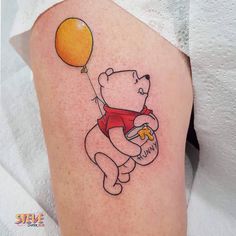 a small tattoo of a bear with a balloon on his arm, holding a cheeseburger