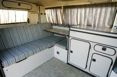 the inside of a camper with two couches and a kitchenette in it