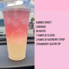 a pink and yellow drink sitting on top of a table next to a car dashboard