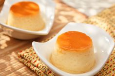 two small white dishes filled with food on top of a bamboo tablecloth covered place mat