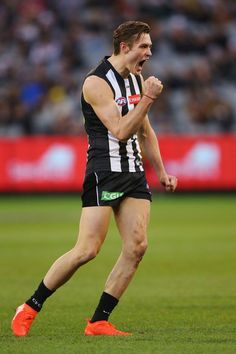 a male afl player celebrates his team's win