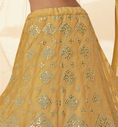 COLOR : Pale Mustard FABRIC : Top (Blouse) - Organza, Bottom (Lehenga) - Organza, Dupatta - Soft Net WORK : Heavy Silk Thread Embroidery, Heavy Foil Mirror Work, Floral Motifs, Lace Border OCCASION : Wedding, Reception, Sangeet, Engagement READY-TO-WEAR : NoSTITCHING : Available as semi-stitched fabric, can be stitched using standard size option (+$30). Note: There might be a slight color variation due to lighting and flash used during photoshoot. The bright shade seen is the best closer view of