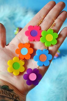 "I love these rainbow crazy daisy earrings in these fun bold colors! Made of lightweight acrylic, these mismatched daisies have different colored centers and are finished with hypoallergenic gold-plated brass fish hooks for closure. Materials: acrylic, hypoallergenic gold-plated brass hardware Measurements: 5.1\" drop length, 1.1\" width, .5oz weight" Cheap Colorful Dangle Earrings, Cheap Multicolor Statement Earrings, Cheap Statement Multicolor Earrings, Colorful Cheap Dangle Earrings, Cheap Quirky Multicolor Earrings, Colorful Handmade Cheap Earrings, Cheap Colorful Artsy Earrings, Affordable Handmade Colorful Earrings, Cheap Vibrant Earrings For Gift