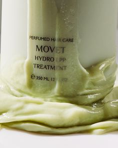 a close up of a bottle of cream on a white surface with the word movit hydro lip treatment written below it