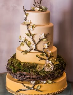 a three tiered cake decorated with flowers and branches