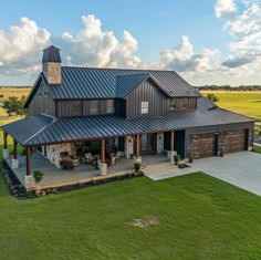 an aerial view of a large house with a metal roof and two car garages