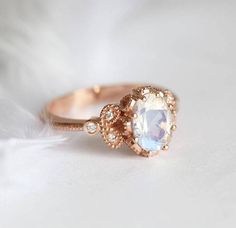 a close up of a ring with an oval stone in the center and small diamonds around it