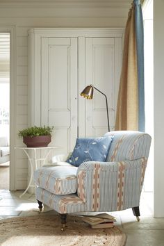 a living room with a chair and a lamp