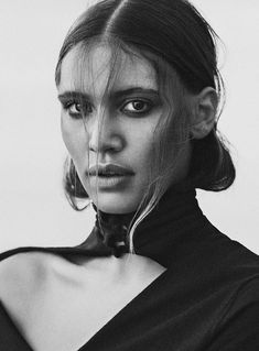 a black and white photo of a woman with her hair in a high pony tail