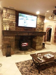 a living room filled with furniture and a flat screen tv mounted on the wall above a fire place