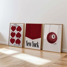 three framed art prints on the wall in an empty room with hard wood flooring