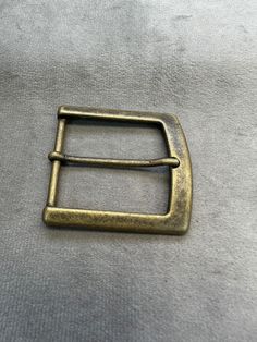 an old brass belt buckle on a gray background