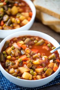 two bowls of vegetable soup with bread on the side