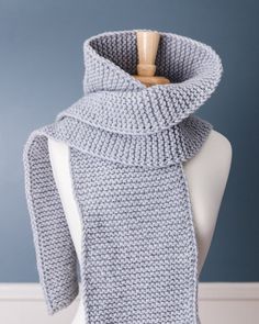 a gray knitted scarf on top of a mannequin