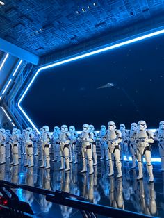 a group of star wars action figures lined up in front of a stage with lights