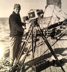 a man standing on top of a boat next to a camera