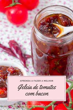 a jar filled with jam sitting on top of a table next to tomatoes and peppers