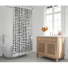 a bathroom with a sink, toilet and shower curtain in black and white designs on it