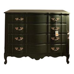 a green dresser with gold handles and drawers