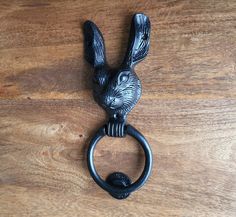 a black metal bunny door knocker on a wooden surface