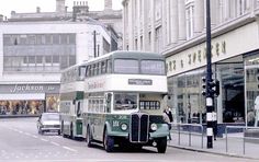 a double decker bus is driving down the street in front of some buildings and people