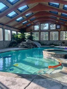 an indoor swimming pool with a slide and water features in the center, surrounded by large windows