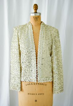 1960s Jacket | Lilli Diamond | Vintage 60s White Silver Sequin Cardigan Evening Jacket All Over Sequin Swirls DETAILS: *1960s evening jacket *Cardigan style- no closure *All over sequin swirls with silver and matte white sequins *White silver nylon base fabric *Clustered sequins around neckline and hems *Shoulder pads *Fully lined LABEL: Lilli Diamond California CONDITION: Near perfect MEASUREMENTS:  Bust= 40" Length from high point shoulder= 22" Sleeve length= 21" Across back shoulder=16" Compare with your own measurements + ease or compare with similar garments in your closet. SHIPPING: This item will ship via USPS Priority Mail domestically and international. All orders have insurance included. NOTE: ALL SALES ARE FINAL. Items are freshly cleaned and ready to wear. All imperfections are Vintage Party Blazer For Winter, Vintage Blazer For Spring Party, Retro Long Sleeve Party Blazer, Vintage Fall Blazer For Parties, Vintage Blazer For Fall Party, Vintage Fall Party Blazer, Vintage Winter Party Blazer, Glamorous Fitted Evening Cardigan, Vintage Fitted Outerwear For Festive Occasions