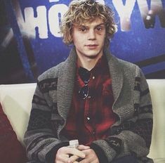 a young man sitting on top of a white couch