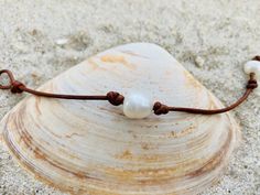 A simple, classic bracelet made from a single freshwater pearl knotted on leather cord. Wear it alone for a clean, minimalist look or stacked with other bracelets for a boho vibe. Choose from three different leather colors. A simple pearl and loop closure makes it easy on and off. The bracelets in the photos are for display purposes. Your bracelet may vary slightly as each is handmade and all pearls are unique. To extend the life of the leather, the necklace should not be worn in the water. The Casual Adjustable Pearl Charm Jewelry, Adjustable Casual Pearl Charm Jewelry, Minimalist Leather Bracelet With Sliding Knot As Gift, Minimalist Leather Bracelet With Sliding Knot For Gift, Minimalist Leather Bracelet With Adjustable Cord, Minimalist Waxed Cord Jewelry For Beach, Beach Bracelet, Leather Colors, Simple Pearl