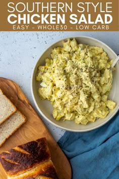 a bowl of chicken salad next to sliced bread on a cutting board and blue towel