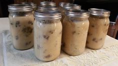 four jars filled with food sitting on top of a table