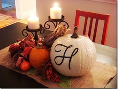 two pumpkins sitting on top of a table next to candles