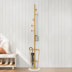 a room with white walls and wooden flooring has a coat rack in the corner