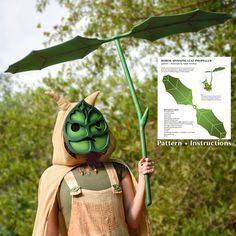 a person wearing a costume and holding an umbrella over their head while standing in front of trees