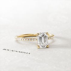 an engagement ring with a large emerald stone surrounded by small white and yellow diamond stones