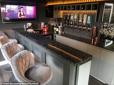 a bar with two chairs and a television on the wall