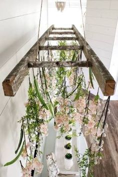 an overhead planter with pink flowers and greenery hanging from it's sides