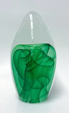 a green vase sitting on top of a white table