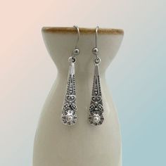 Introducing our Antiqued Silver Boho Flower Earrings, the perfect everyday accessory that effortlessly blends casual charm with a touch of vintage elegance. These beautifully detailed earrings boast an antiqued silver finish, lending them a soft and rustic appearance. Their long and slender shape, measuring 27mm x 8mm, makes them an ideal choice for both casual and dress-up occasions. The intricate flower design adds a touch of delicacy to these earrings, elevating their overall appeal. For utmo Vintage Hypoallergenic Drop Earrings, Hypoallergenic Vintage Drop Earrings, Classic Silver Teardrop Earrings Gift, Silver Dainty Earrings With French Hook, Antique Silver Drop Earrings, Vintage Silver Teardrop Pierced Earrings, Vintage Silver Teardrop Earrings, Vintage Nickel-free Teardrop Earrings, Elegant Antique Silver Earrings As Gift