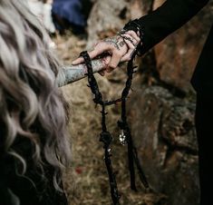 two people holding hands with chains attached to them and one person is holding a knife in the other hand