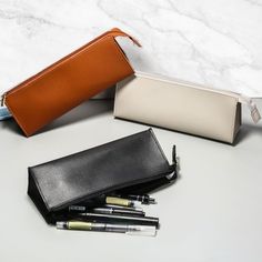 Supply your office in style with my high-quality PU Vegan leather stationery bag, available in classic black or grey with matching metal zippers. This sleek & functional pouch measures approximately 8 x 3 x 2 inches (20 x 6 x 6 cm), making it the perfect size for storing your favorite pens & pencils. Whether you're a student looking to keep your school supplies in order or an artist in need of a convenient way to store your writing tools, these luxurious stationery storage cases have got you cov Leather Pencil Pouch, Luxury School Supplies, Designer Pencil Case, Versatile Zipper Pouch Pencil Case For School, Versatile School Pencil Case With Zipper, Versatile Portable Pencil Case For School, Versatile Rectangular Pencil Case With Pen Slots, Classic Rectangular Pencil Case For Daily Use, Modern Rectangular Pencil Case For Everyday Use