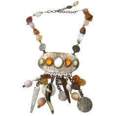 Phillipe Ferrandis Paris Artisan glass stone dangling charm necklace c 1980s The exotic burnished silver-tone necklace is comprised of a collection of smooth glass stones, translucent crystals, resin cabochons with series of dangling burnished silver metal mock coins The large-scale statement necklace makes a rattling sound from the collection of dangling embellishments Designed by Phillipe Ferrandis Measurements The necklace maximum length measured flat end to end = 21 in The necklace length ex Bronze Metal Necklace With Natural Stones, Bronze Metal Necklaces With Natural Stones, Bronze Necklaces With Natural Stones, Handmade Amber Metal Necklace, Collectible Bohemian Amber Jewelry, Bohemian Metal Necklaces With Stones, Bohemian Amber Jewelry With Large Pendant, Vintage Metal Necklace With Stones, Vintage Pendant Jewelry With Stones