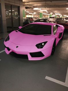 a pink sports car parked in a parking garage