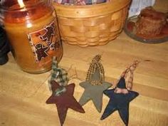 three wooden stars sitting on top of a table next to a mason jar and candle