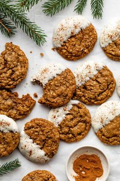 cookies with white frosting and cinnamon on top, surrounded by pine branches in the background