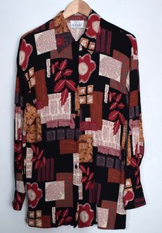 Vintage 90s women's blouse with a mixed print in autumn colors. The blouse features abstract print, leafs and flowers print and text print on a black background. The blouse has a free falling boxy shape, a collar and side slits on the bottom hem Made in England Material - 100% viscose, fabric has a wrinkly effect! Size - M/L. Please look at measurements to see if it will fit you the way you want it to Approx. Measurements ( taken when blouse lying flat, double armpit to armpit ): Shoulder to Sho Patterned Graphic Print Shirt For Fall, Patterned Shirt With Graphic Print For Fall, Multicolor Graphic Print Shirt For Fall, Fall Abstract Print Button-up Blouse, Multicolor Print Long Sleeve Shirt For Fall, Fall Multicolor Graphic Print Shirt, Fall Patterned Printed Shirt, Graphic Print Button-up Blouse For Fall, Fall Graphic Print Button-up Blouse