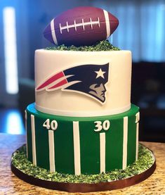 a three tiered cake with footballs on top