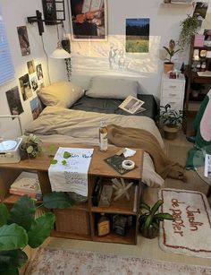 a bed room with a neatly made bed and lots of pictures on the wall above it