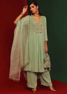 Features a jade georgette kurta with sequin work velvet yoke and 3D embellishments at the hem. This V-neck kurta has circular tassels on the sleeves hem. Paired with hem tasseled dupatta. An ideal indo western pick for Mehendi and wedding guests. Composition : Kurta and Pants: Georgette, Dupatta: Organza, Lining: Shantoon Care: Dry Clean Only and Vacuum Storage All products can be customised for sleeves, length of blouse and neck design Delivery : 4-6 weeks as the product is hand crafted. Check Georgette Kurta Sets For Women, Mahima Mahajan, Kurta Set With Dupatta, Lehenga Style Saree, Indian Bridesmaid Dresses, Color Jade, Indian Wedding Wear, Indian Suits, Straight Kurta